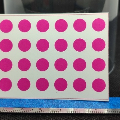 Cartolina com pontos cor-de-rosa e régua metálica em fundo preto
