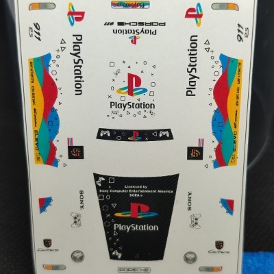 Autocolante para Porsche 911 Carrera RS 2.7 com logótipos PlayStation, Sony, Porsche e detalhes coloridos.