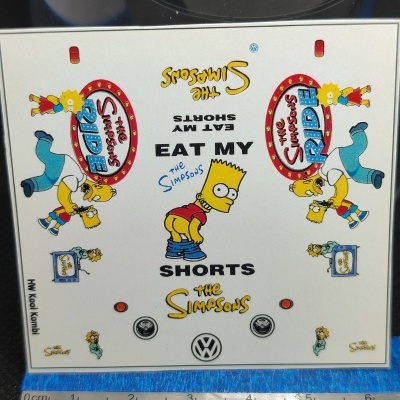 Autocolante branco com desenhos dos Simpsons e texto Eat My Shorts e The Simpsons Ride.