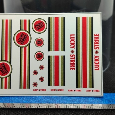Autocolantes Lucky Strike com faixas vermelhas, pretas e amarelas e texto vermelho
