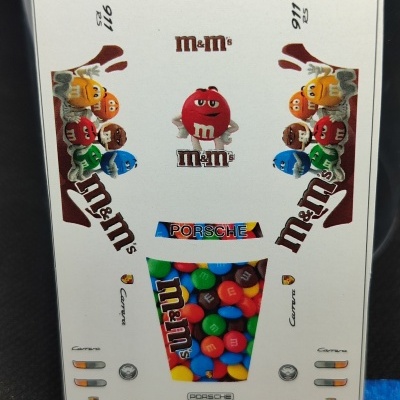 Folha com autocolantes M&Ms e Porsche em várias cores e personagens em fundo branco