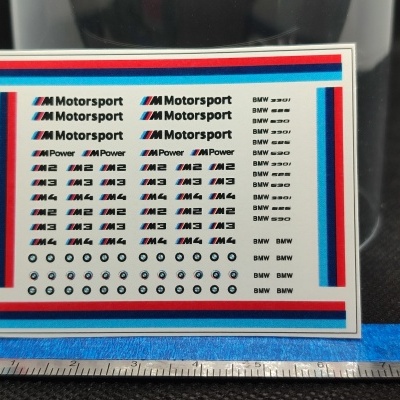 Folha de autocolantes BMW Motorsport com logos coloridos e régua para escala