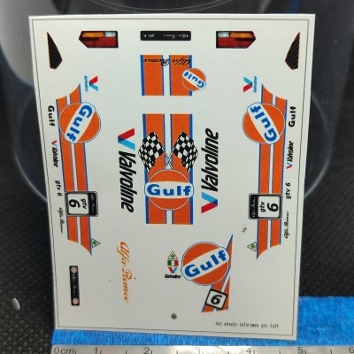Folha de decalques para modelos com logos Gulf, Valvoline, Alfa Romeo e faixas laranja e azul.