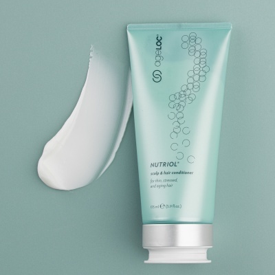 Condicionador AgeLOC Nutriol com amostra cremosa branca sobre fundo azul claro