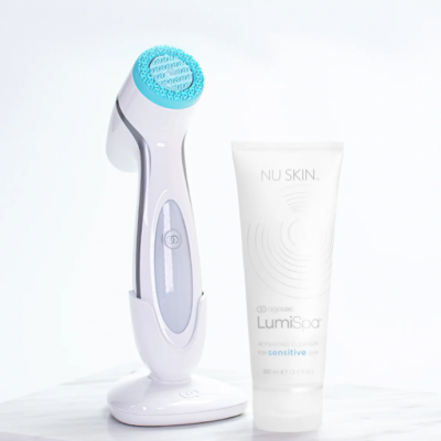 Dispositivo facial branco com pincel azul e tubo branco de creme Nu Skin LumiSpa sobre superfície branca