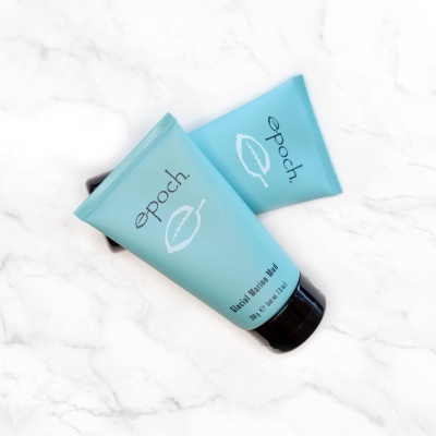 Dois tubos azuis claros com tampa preta e texto 'epoch', sobre fundo branco marmoreado.