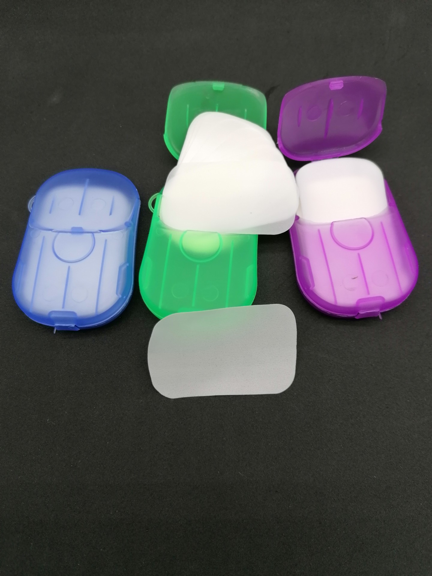 Três caixas plásticas coloridas com pastilhas dentífricas brancas