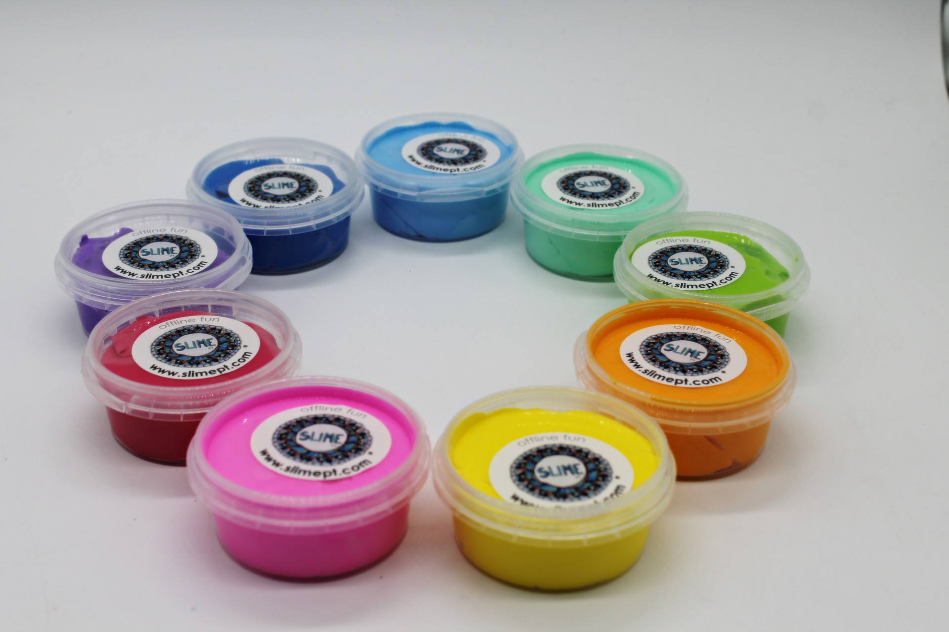 Recipientes plásticos com slime colorido em círculo