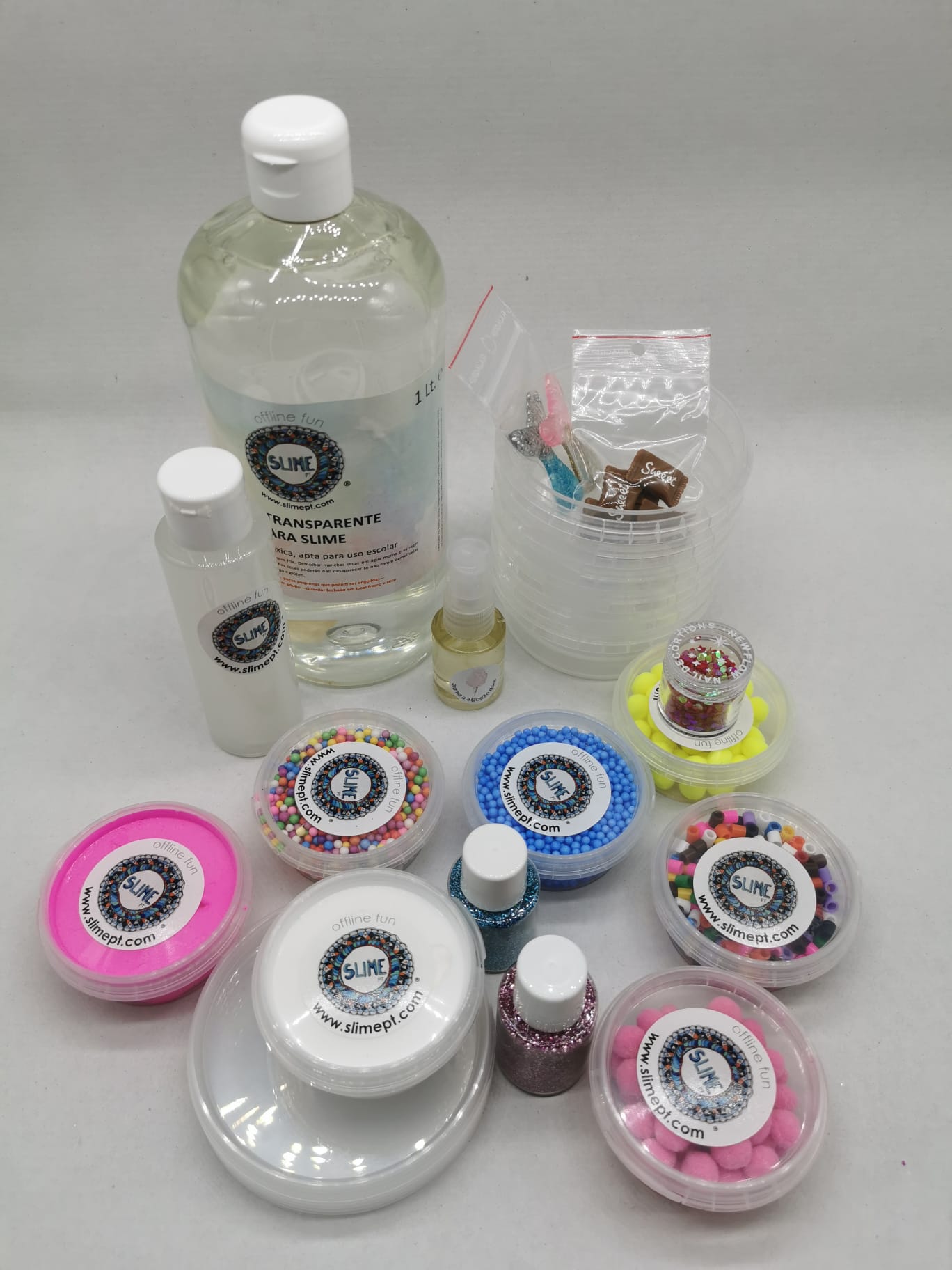 Conjunto de produtos para fazer slime com frascos de cola, líquidos coloridos e recipientes com contas e esferas coloridas