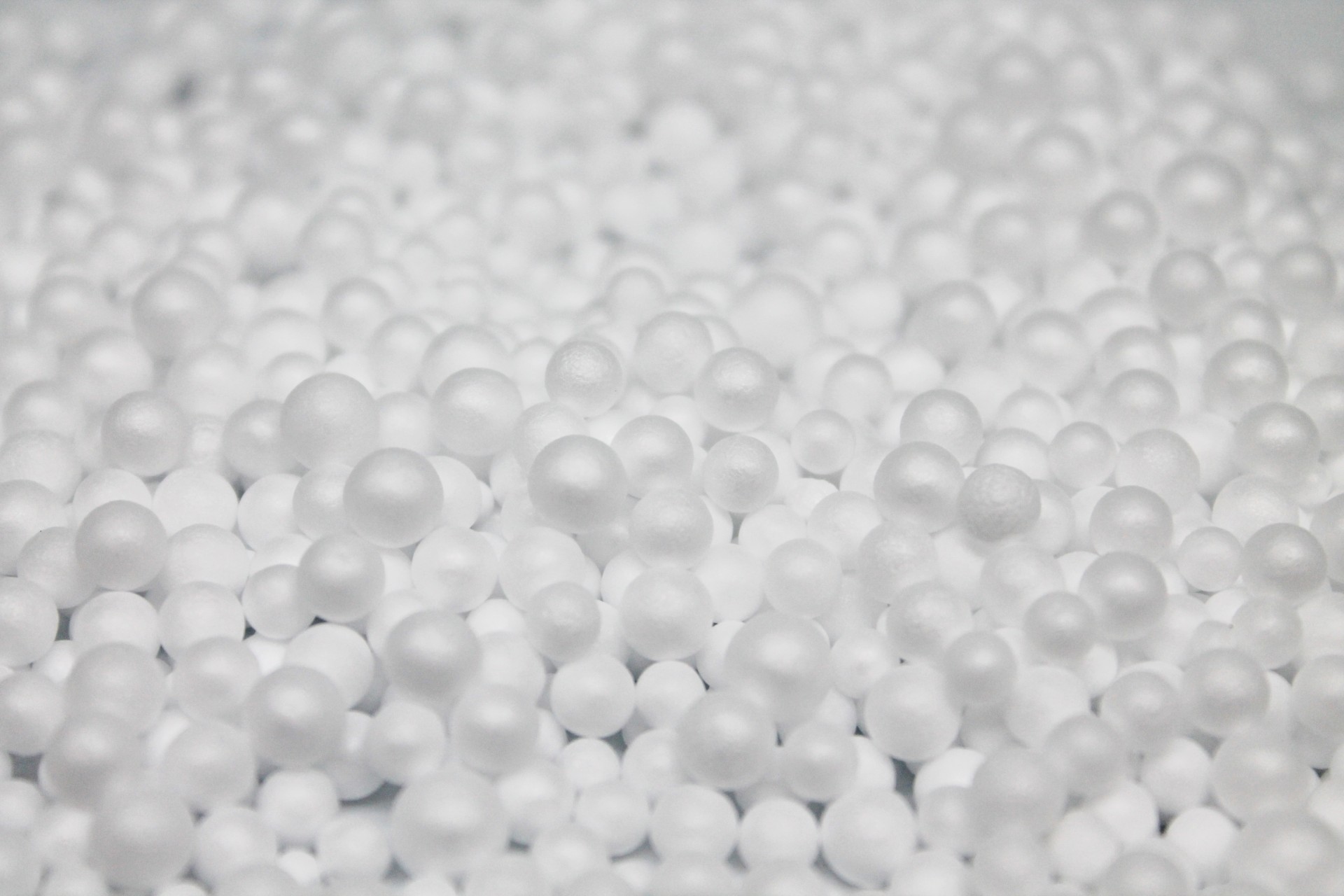 Pequenas bolas brancas de espuma empilhadas com textura lisa e fosca