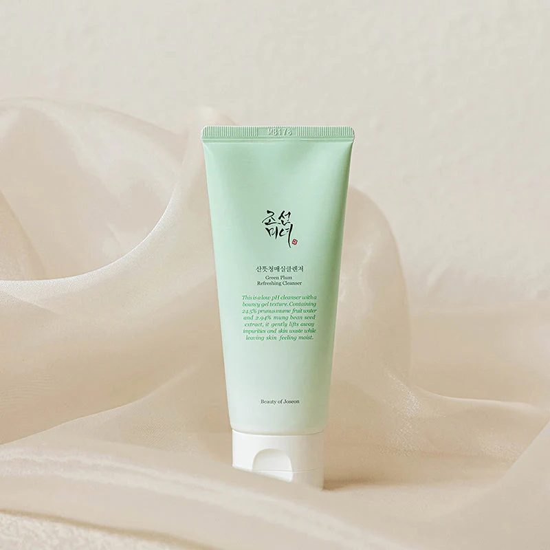 Beauty of Joseon Gel de Limpeza Refrescante Green Plum 100ml Embalagem verde clara de tubo cosmético com texto em inglês e coreano sobre tecido bege