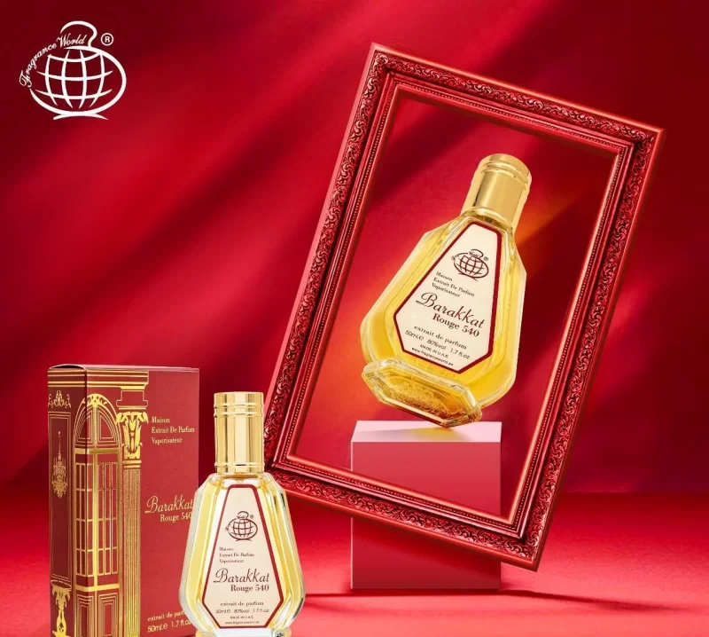 PERFUME EXTRAIT BARAKKAT ROUGE 540 - MULHER Garrafa de vidro com líquido amarelo e caixa dourada em fundo vermelho com quadro e espelho.