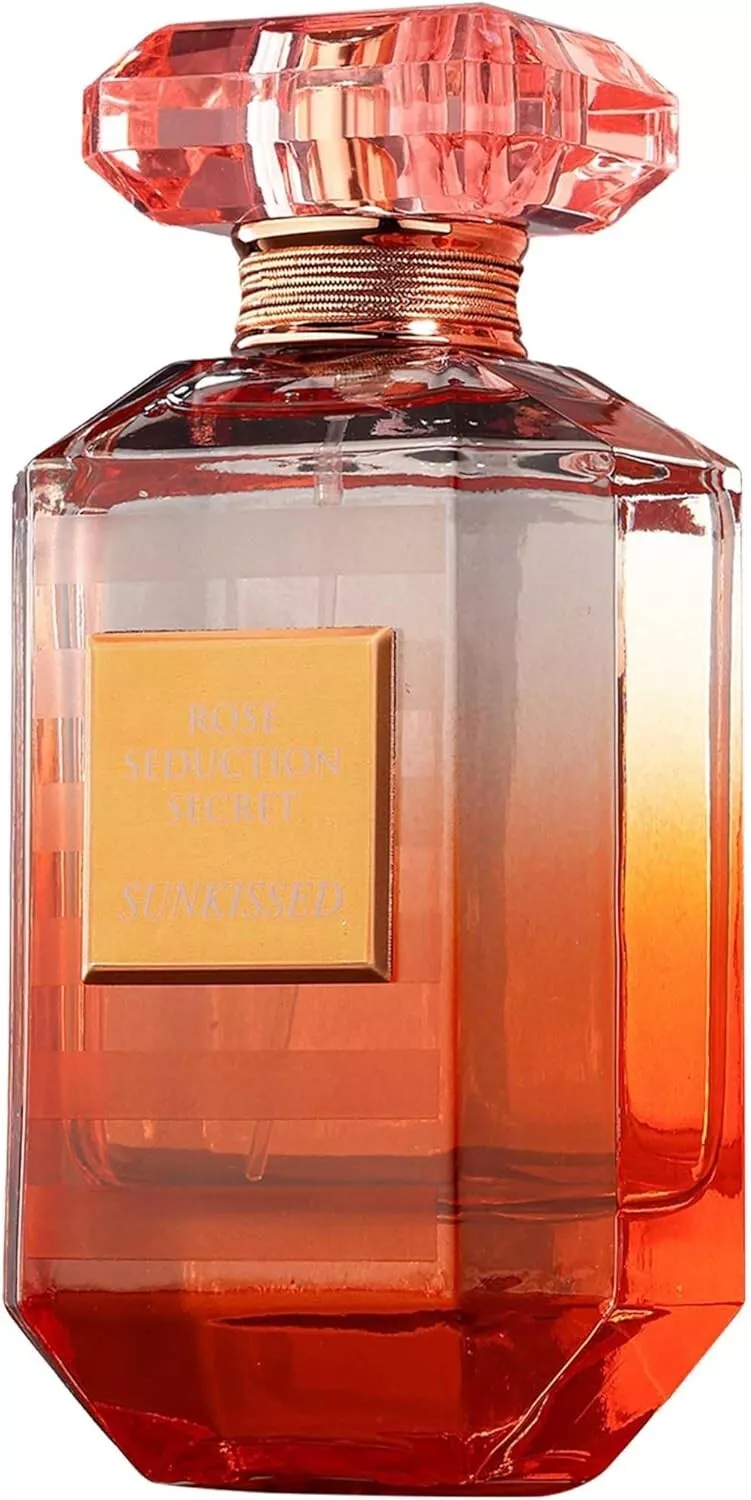 Fragrance World Rose Seduction Secret Sunkissed | 100ml Frasco de perfume em vidro translúcido laranja-vermelho com tampa rosa e etiqueta dourada.