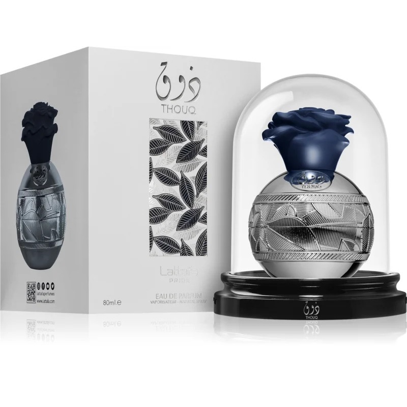 Thouq Lattafa Unissex 80ml Frasco de perfume com padrão folhas e tampa azul em cúpula transparente junto a embalagem branca com design folhas pretas