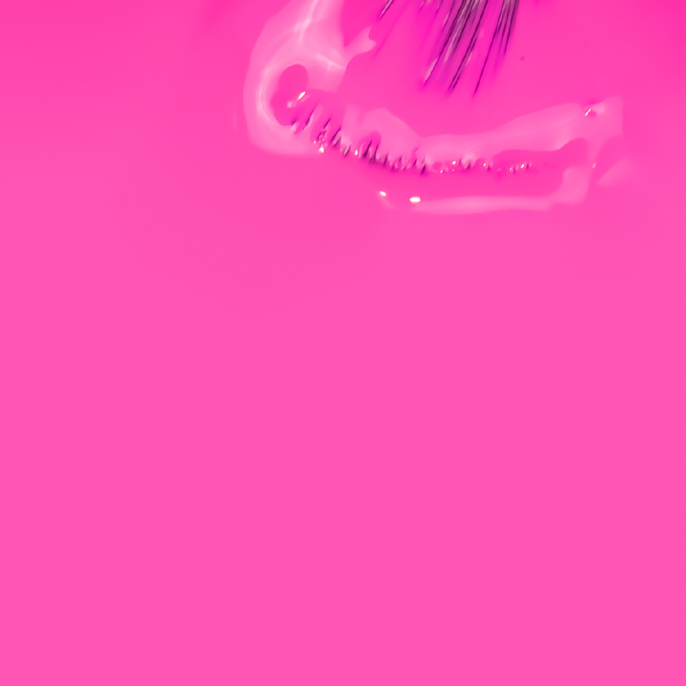 VERNIZ GEL INOCOS NA MOUCHE Objeto de vidro transparente sobre fundo rosa