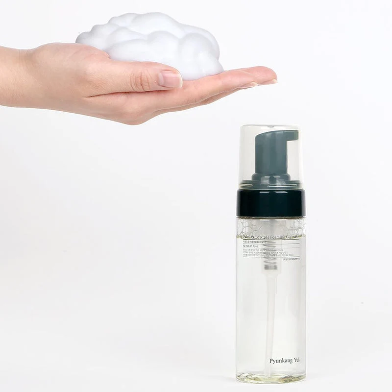 Pyunkang Yul Calming Moisture Low Ph Foaming Cleanser 150 Ml Frasco transparente com bomba preta e espuma branca na mão