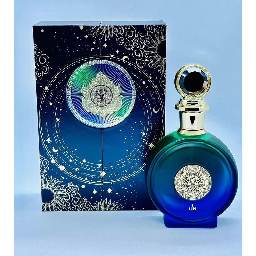Frasco de perfume azul com tampa prateada ao lado de caixa decorada azul escura com padrão celestial