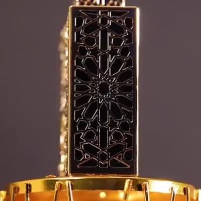 Garrafa de perfume dourada decorativa com padrão geométrico exibida em vários ângulos