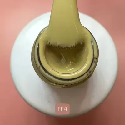 Frasco branco com tampa amarela e código FF4 em fundo rosa