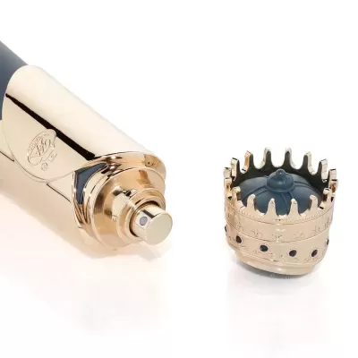 Frasco de perfume dourado com tampa de coroa e detalhes azul escuro