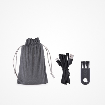 Saco de tecido cinzento, cabo USB preto trançado e escova pequena preta com pêlos.
