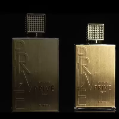 Dois frascos dourados de perfume PRIVE com tampa quadrada, texto gravado.