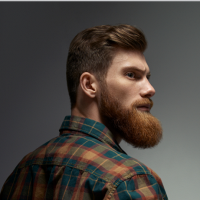 Homem de perfil com camisa xadrez e barba espessa