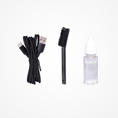 Cabo USB preto, escova pequena preta, frasco plástico transparente com líquido