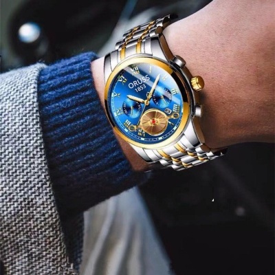 Relógio Orus 1853 com mostrador azul e bracelete metálica bicolor no pulso