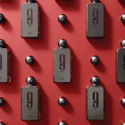 Frascos de perfume com rótulo número 9 e tampas pretas sobre fundo vermelho