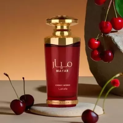 Frasco de perfume vermelho e dourado com cerejas ao redor