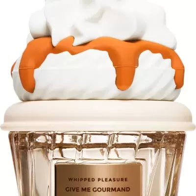 Frasco de vidro com tampa em forma de chantilly e calda laranja, etiqueta com texto.