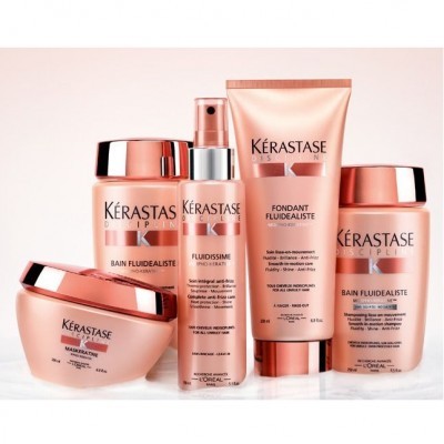 Produtos Kérastase Discipline em embalagens rosa e cobre sobre superfície branca