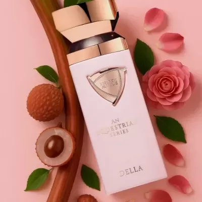 Frasco de perfume branco com tampa dourada e decoração natural sobre fundo rosa