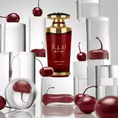 Frasco de perfume vermelho e dourado com cerejas dentro e fora de cilindros transparentes