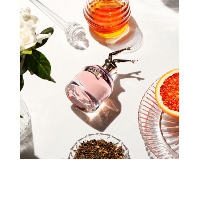 Frasco de perfume com líquidos e alimentos naturais em fundo branco