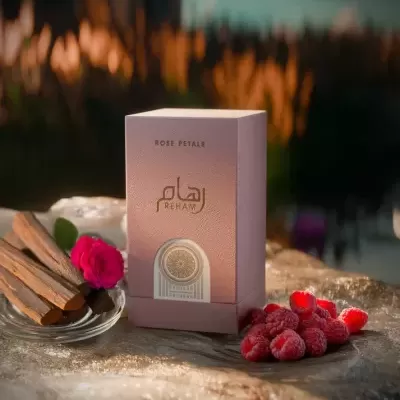 Caixa de perfume rosa Reham com paus de madeira, rosa vermelha e framboesas ao redor em luz quente