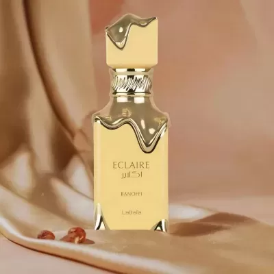 Frasco dourado de perfume ECLAIRE Banoffi Lattafa em tecido dourado
