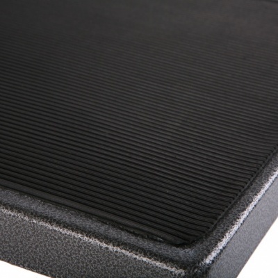 Superfície de tábua preta com textura canelada e bordas arredondadas rugosas