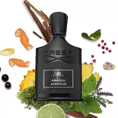 Frasco preto de perfume CREED ABSOLU AVENTUS com ingredientes naturais ao redor