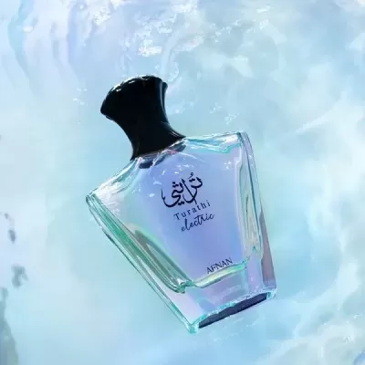 Frasco de perfume em líquido roxo com tampa preta sobre superfície de água