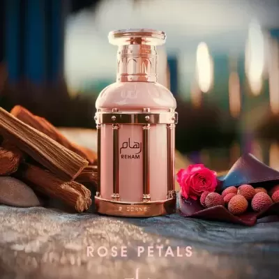 Frasco de perfume rosa com detalhes dourados e elementos naturais
