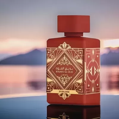 Frasco de perfume vermelho com decoração dourada e texto BADEA AL OUD