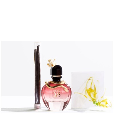 Frasco de perfume rosa com tampa preta e decoração, tubo com hastes à esquerda e caixa branca com desenho amarelo à direita