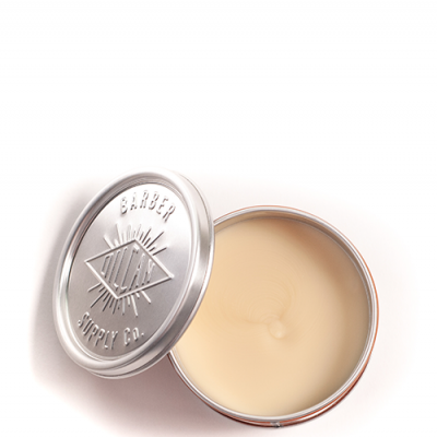 Pote metálico prateado com pomada bege clara aberta