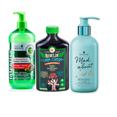 Três frascos de produtos para cabelo: shampoo verde, shampoo preto colorido e creme azul claro, cada um com texto e rótulos distintos