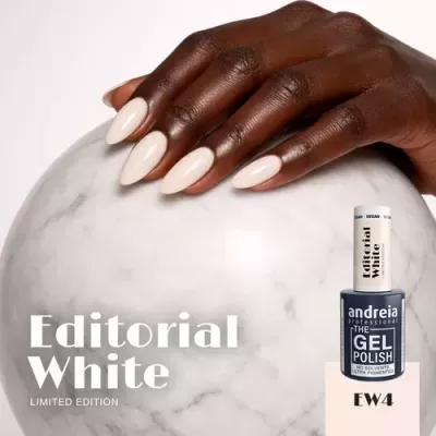 Mão com unhas pintadas de branco sobre esfera de mármore com frasco de verniz gel