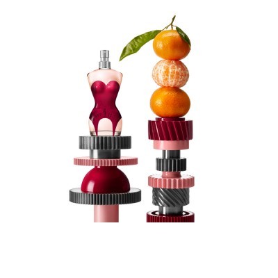 Frasco de perfume em forma de corpo feminino com tangerinas e engrenagens