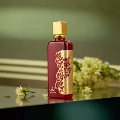 Frasco de perfume vermelho com tampa dourada e padrão floral com texto BAREZ