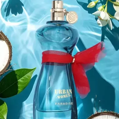 Frasco de perfume azul com laço vermelho e tampa dourada sobre fundo azul com folhas e flores